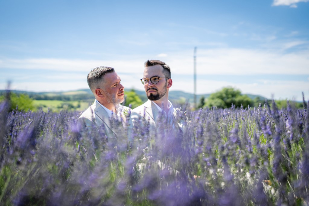 Jan and Phil in the blooming lavender field with hills in the distance