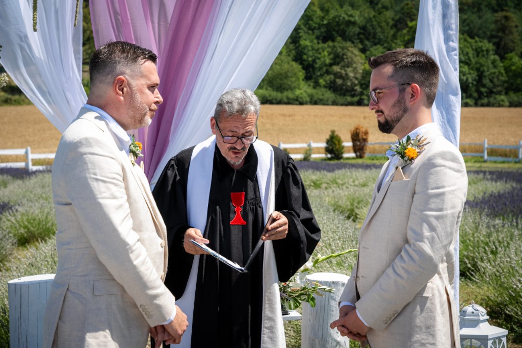Outdoor ceremony with officiant, profile view and lavender behind