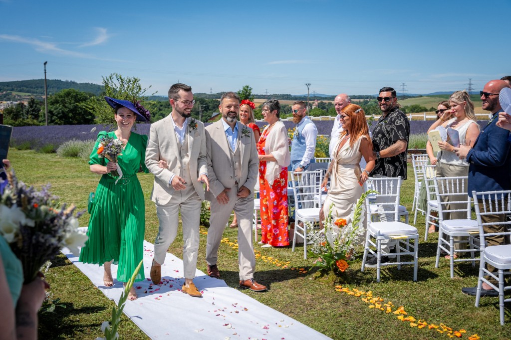 Recessional along the aisle with a guest in a green dress