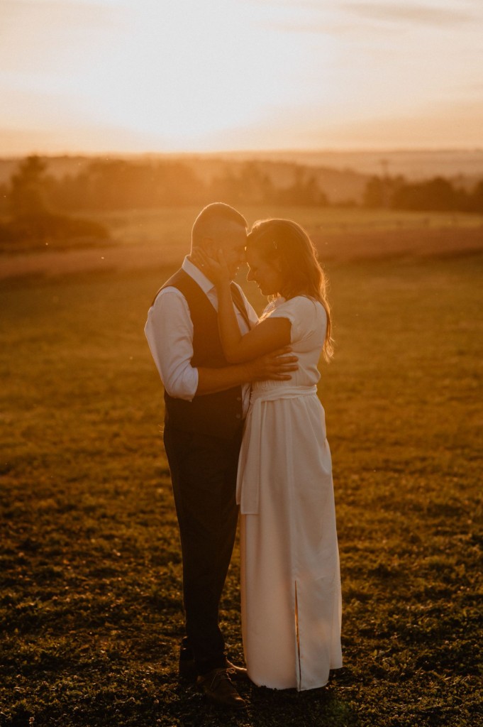 Newlyweds walking hand in hand between rows of blooming lavender